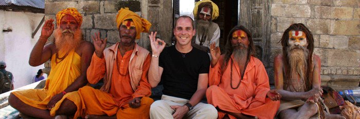 Tourist sitzt mit Mönchen auf einer Steintreppe