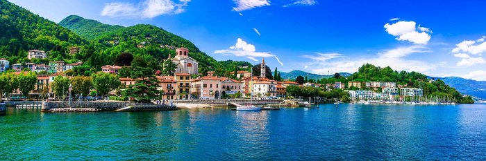 Hafen von Laveno am Lago Maggiore, umgeben von Wasser, grünen Bergen und der malerischen Landschaft der Lombardei, Italien.