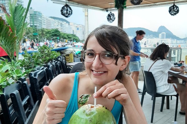 Reiseberaterin Alexandra Otting in einem Lokal sitzend mit Kokosnuss auf dem Tisch.