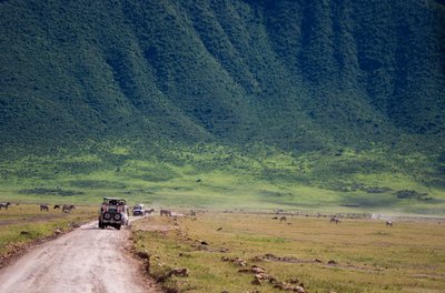 Ein Safari-Jeep fährt durch die beeindruckende Landschaft des Ngorongoro-Kraters