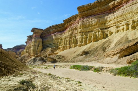 Wanderer vor einer Felswand in der Namib Wüste in Angola.