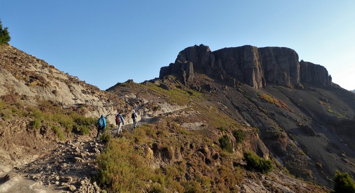 Drei Wanderer in Gebirgslandschaft