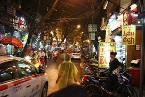 Belebte Straßenszene am Abend in Hanoi mit viel Verkehr auf der Straße