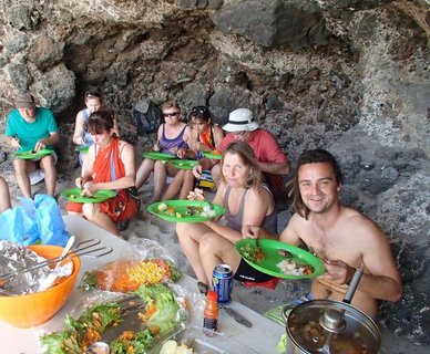 Die Reisegruppe am Essen bei einem BBQ vor einer Steinwand
