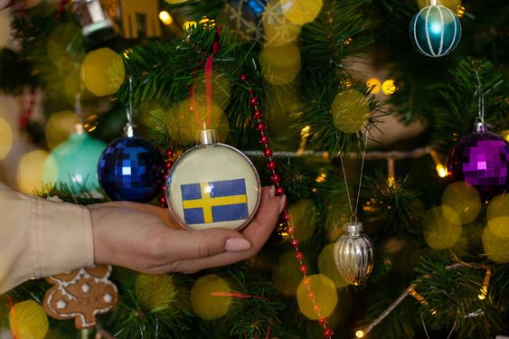 An einem Weihnachtsbaum hängt eine Kugel mit einer Schweden-Flagge